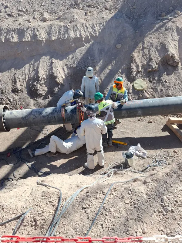Cuadrilla WPS soldando una unión de pipeline dentro de la zanja